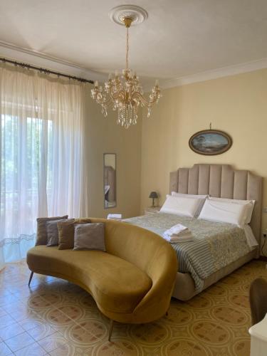 a bedroom with a bed and a couch and a chandelier at Villa Favorita Suites in Ercolano