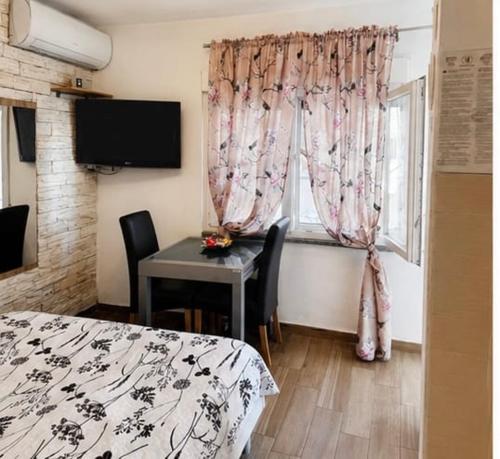 a room with a bed and a table and a window at Apartment Vrančić in Šibenik