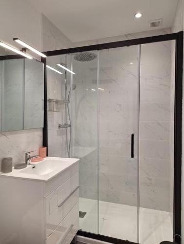 a white bathroom with a shower and a sink at Le Clos Cecile'Ann in Fréchou