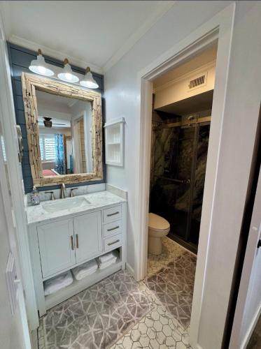 a bathroom with a sink and a mirror at Caribbean LYMM Cottage in Carolina Beach