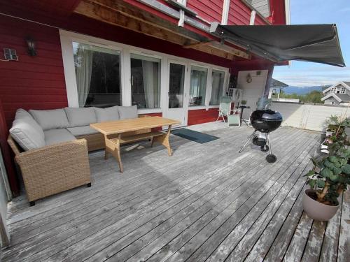 a patio with a couch and a table and a grill at Artic home komfort in Tromsø