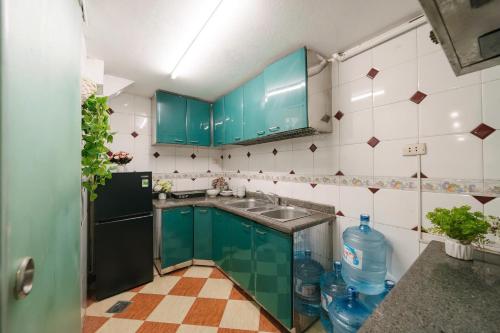 a kitchen with green cabinets and a sink at Morden Apt 6Br Old Quater in Hanoi
