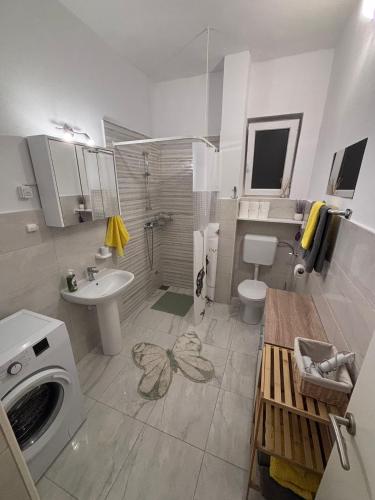 a bathroom with a sink and a washing machine at Apartmani Milka in Vrsi