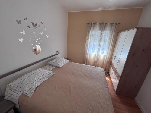 a bedroom with a bed with butterflies on the wall at Apartmani Milka in Vrsi