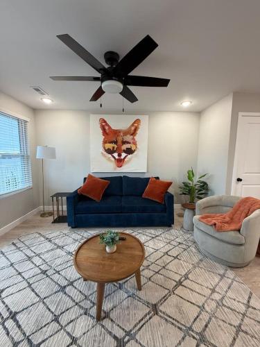 a living room with a blue couch and a cat face on the wall at Lake of the Ozarks Waterfront Kapilana Resort Condos - Pool, Dock, Grill, Boat Rentals Fishing & Lake Views in Osage Beach