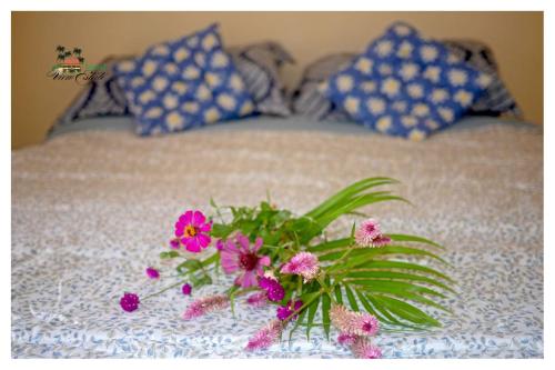 a vase with flowers sitting on a bed at Island View Estate in Kingstown