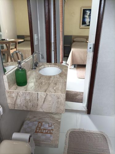 a bathroom with a sink with a green candle on it at Flat Vista do Cruzeiro in Jacobina