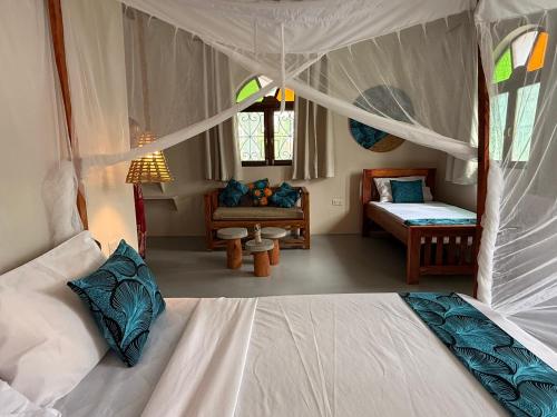 a bedroom with two beds and a couch in a room at Bahari Paje Beach House in Paje