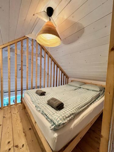 a bed in a wooden room with a ceiling at Domki nad morzem Sasino Mojo Miodno Checz in Sasino
