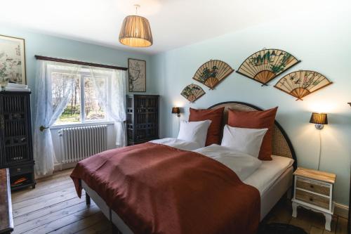 a bedroom with a bed with blue walls and a window at Broløkke Herregård in Humble