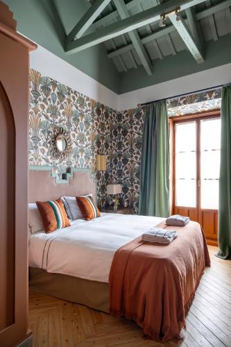 a bedroom with a large bed in a room at Hotel Boutique Casa Treviño in Campo de Criptana