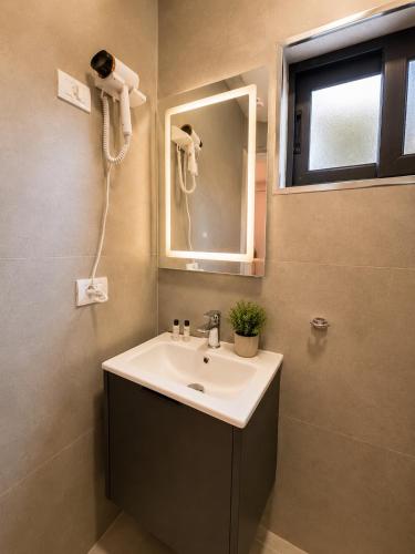 a bathroom with a sink and a mirror at Casa Del Sol Seaside Hotel in Durrës