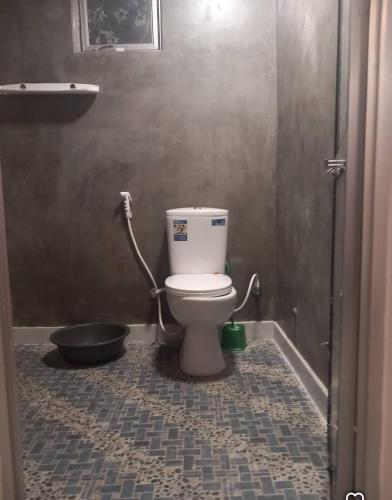 a bathroom with a toilet with a bucket in it at Amith Villa in Koggala