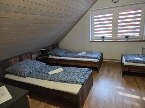 a room with three beds in a attic at Domek Lipowy BALIA-jacuzzi in Sasino