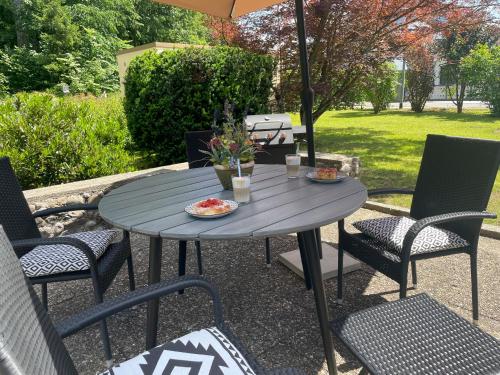 a patio table with chairs and an umbrella at Allgäu Bungalow GLOW in Isny im Allgäu
