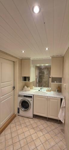 a kitchen with a washing machine and a sink at Villa Thorse in Husvik