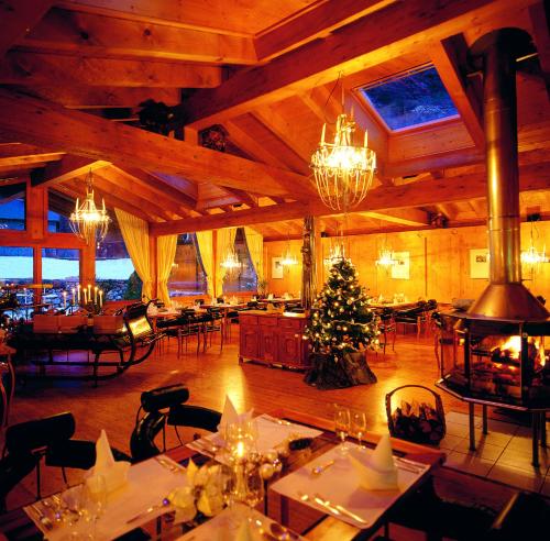 ein Restaurant mit einem Weihnachtsbaum in der Mitte des Zimmers in der Unterkunft Loftsuite Hotel Saas in Saas-Almagell