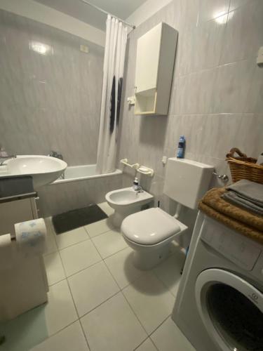 a bathroom with a toilet and a sink and a bath tub at Appartamento Catalina in Saint-Pierre