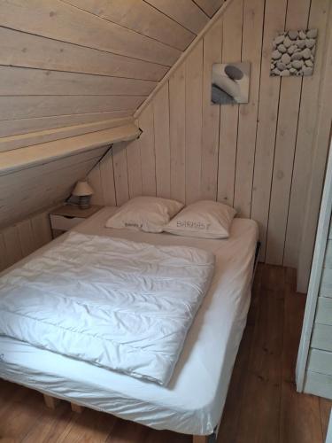 a bed in a room with a wooden floor at Casa Ysermonde- Barkas 8 in Nieuwpoort