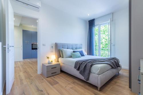 ein weißes Schlafzimmer mit einem Bett und einem Fenster in der Unterkunft Lamagia in Bologna