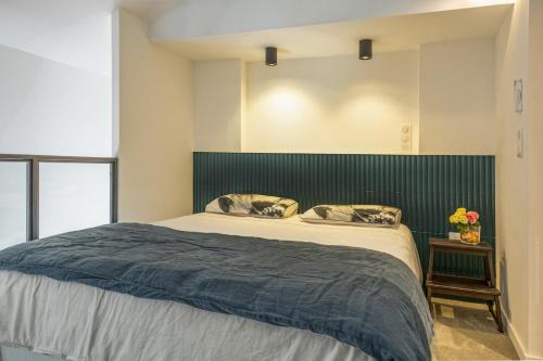 a bedroom with a large bed with a green headboard at Casa Campinchi in Bastia