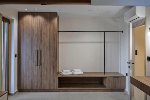 a bathroom with a glass door with two towels on a shelf at Villa Rock&SeaView in Livanates