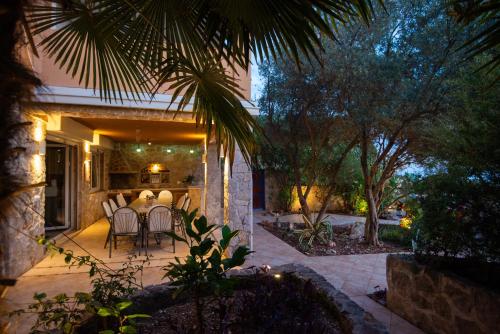 a patio with a table and chairs in a house at Vila Veslo in Begovići
