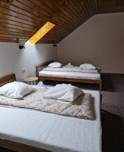 a room with three beds with white sheets at Complex Alena in Ranca