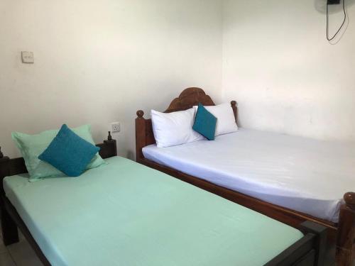 two beds sitting next to each other in a room at SuiteSpot Guest House in Anuradhapura