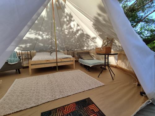 a room with a tent with a bed and a table at Anniksson Glamping Telk- Loodustelk in Virtsu