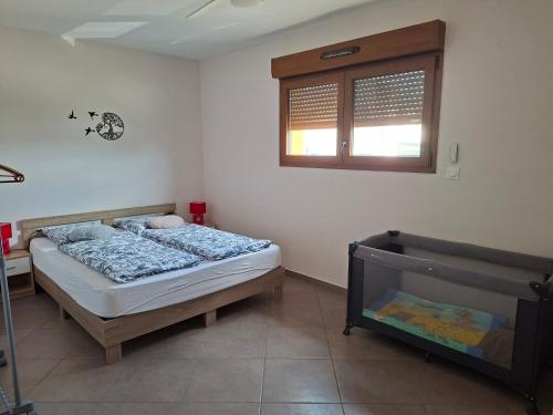 a bedroom with a bed and a window at Apartment Einliegerwohnung in Hagenthal-le-Haut