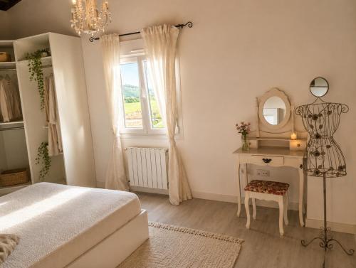 a bedroom with a bed and a dressing table and a mirror at Casa de campo en alava in Ollávarre