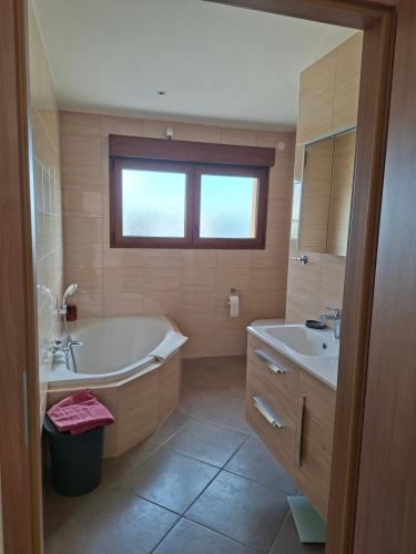 a bathroom with a tub and a sink at Apartment Einliegerwohnung in Hagenthal-le-Haut