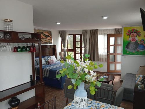 a room with a bed and a vase of flowers on a table at Cómodo departamento en Xochimilco in Mexico City