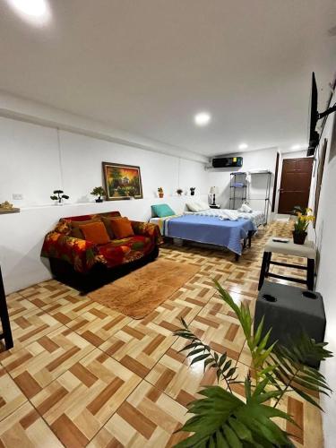 a bedroom with a bed and a couch in a room at Apartamento El Almendro in Liberia