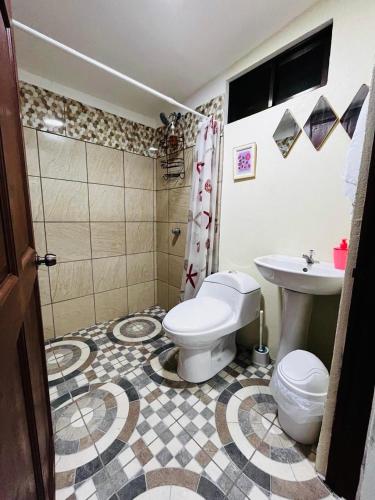 a bathroom with a toilet and a sink at Apartamento El Almendro in Liberia