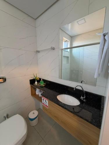 a bathroom with a sink and a mirror at Priamo Hotel in Santo Antonio do Sudoeste