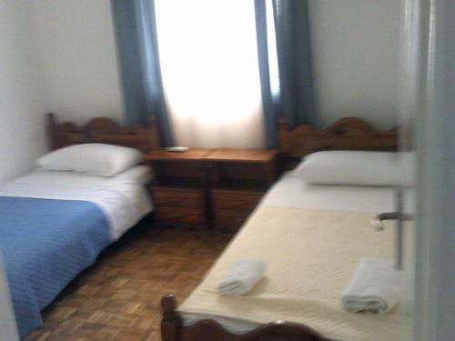a small room with two beds and a window at ΑΚ City Apartment 1 in Ágios Rókkos