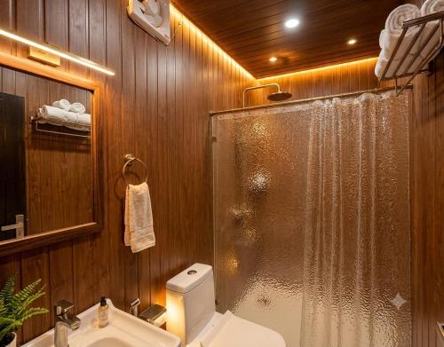 a bathroom with a shower and a toilet and a sink at The Chapter Stay - Kedarnath in Phata