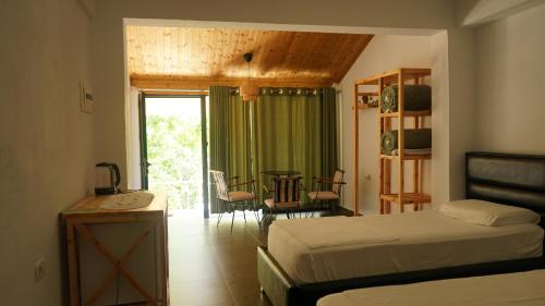 a bedroom with two beds and a table and chairs at Life on Green in Himare