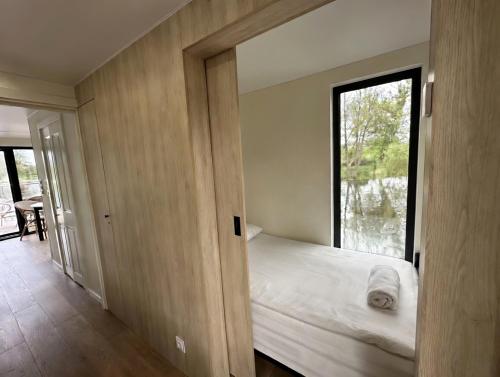 a small bedroom with a bed and a window at Pensjonat Bobrowy Dwór in Szelków Stary