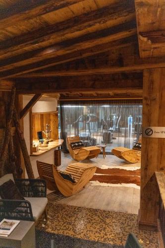 a living room with wooden ceilings and chairs and a table at Hotel Etrier in Crans-Montana