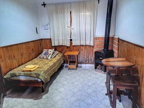 a bedroom with a bed and a wood stove at SumayWasi in Tilcara
