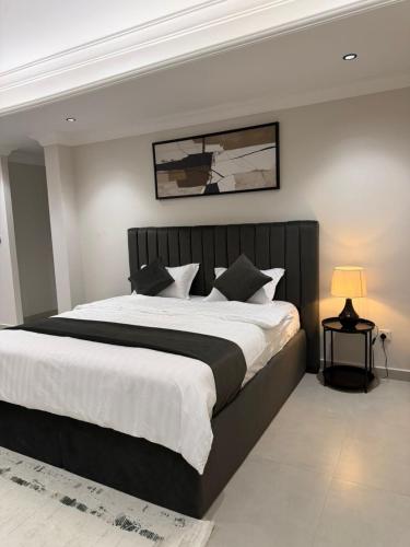a bedroom with a large bed with a black headboard at Studio in South Khobar in Al Khobar