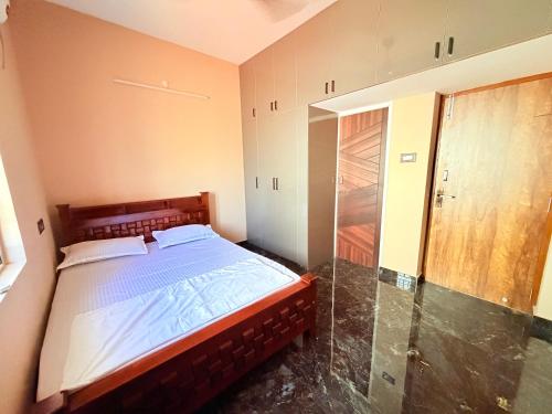 a bedroom with a bed and a glass door at Vihaalaya stays in Tozhuppedu