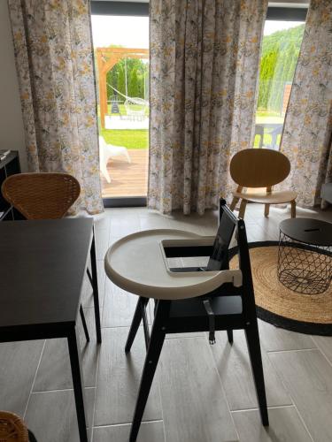 a table with a laptop on a chair in a room at Domek pod Sosnową Górą in Żelazno