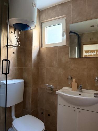 a bathroom with a toilet and a sink and a mirror at Splendid corner in Bečići