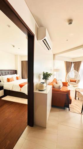 a bedroom with a bed and a couch at Resort Living 1BR Corner Apartment with Balcony in Maribago