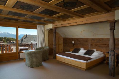 a bedroom with a bed and a balcony at Hotel Etrier in Crans-Montana