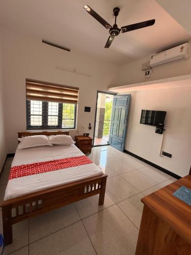 a bedroom with a bed and a ceiling fan at Lakeside Meadows- Diamond Homestay in Kollam